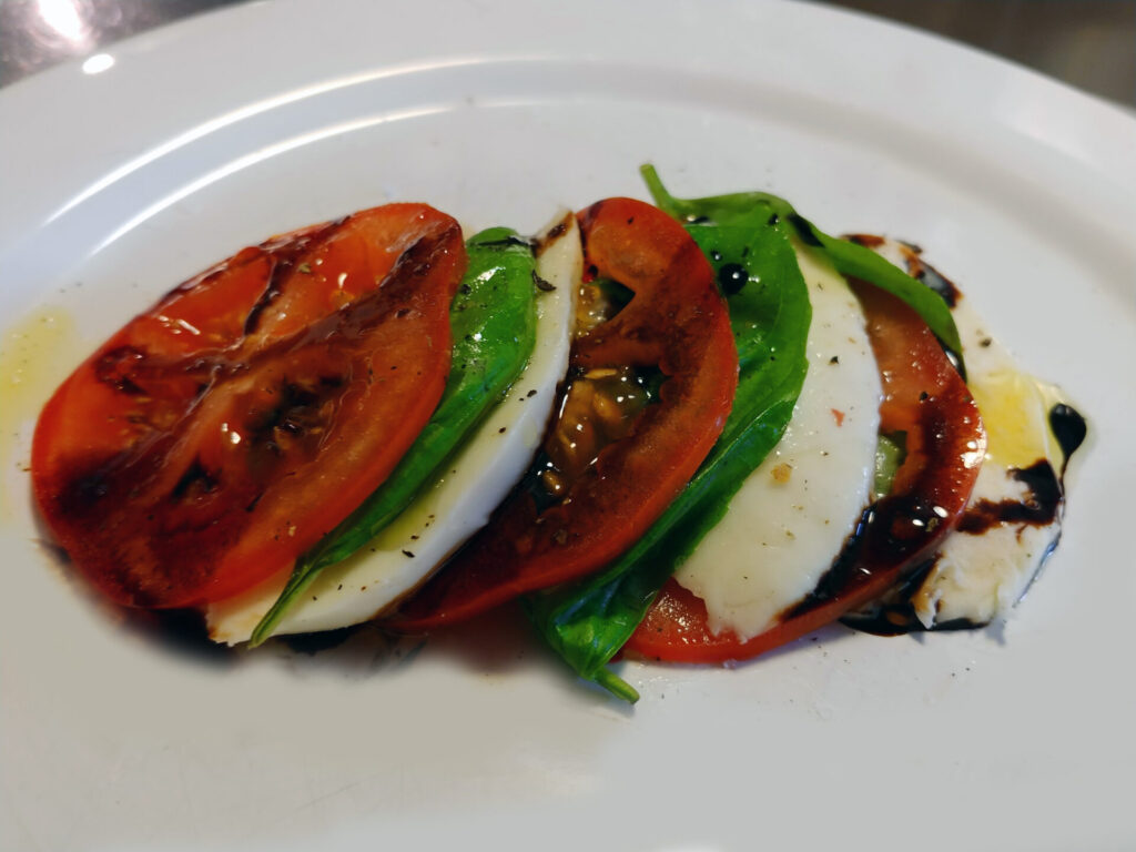 Caprezse Salad in detail on the white plate, side shot