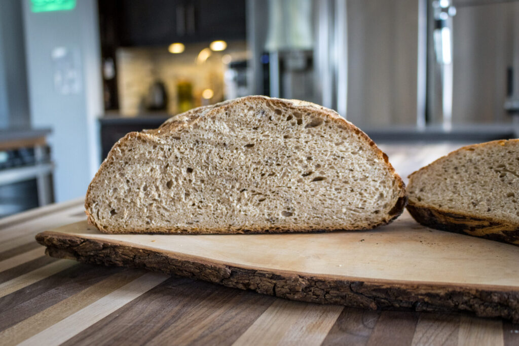Example of Bread and Baguettes: Rye Bread on the cututtingboard, cut to showcase the inner part, kitchen in the background