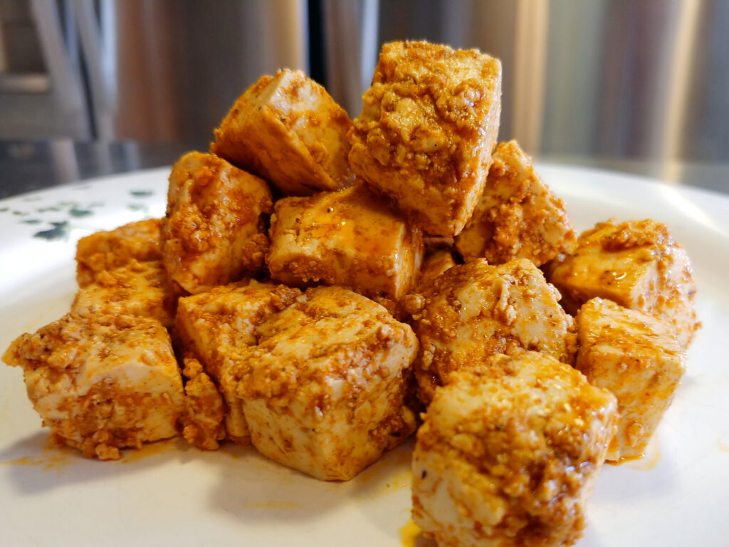 Tofu Bites in detail, on the plate, with refrigerator in the background