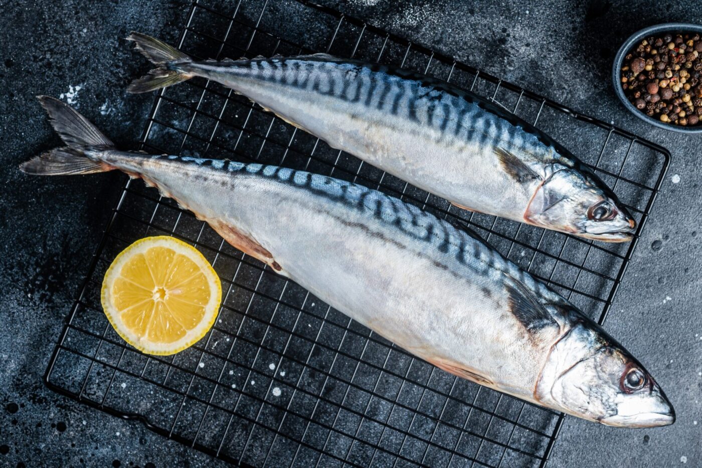 Fresh Raw mackerel scomber fish ready for grilling. Black background. Top view