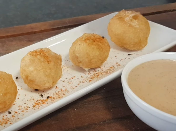 Cheese Balls on the long and thin white plate, dark brown surface