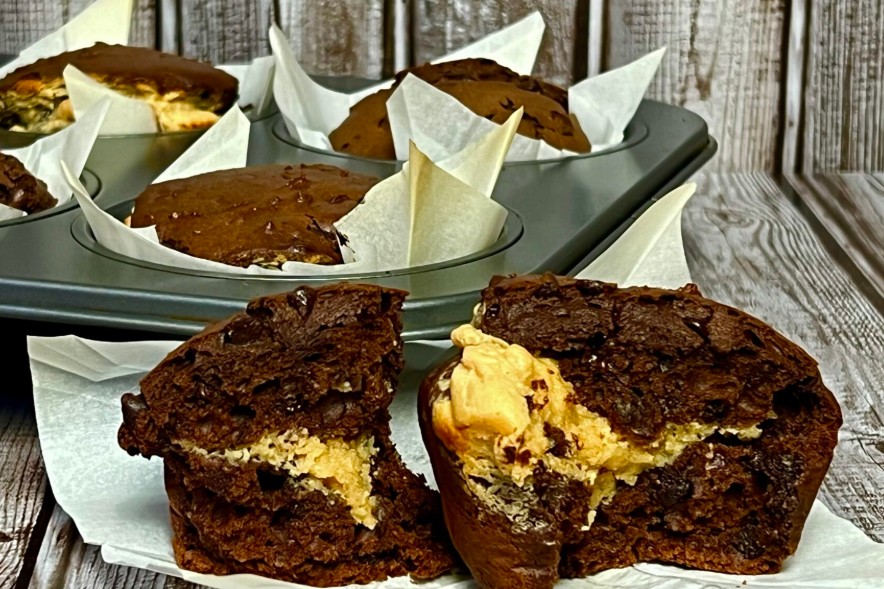 Chocolate Peanut Butter Cheesecake Muffins on the plate and on the tray behind