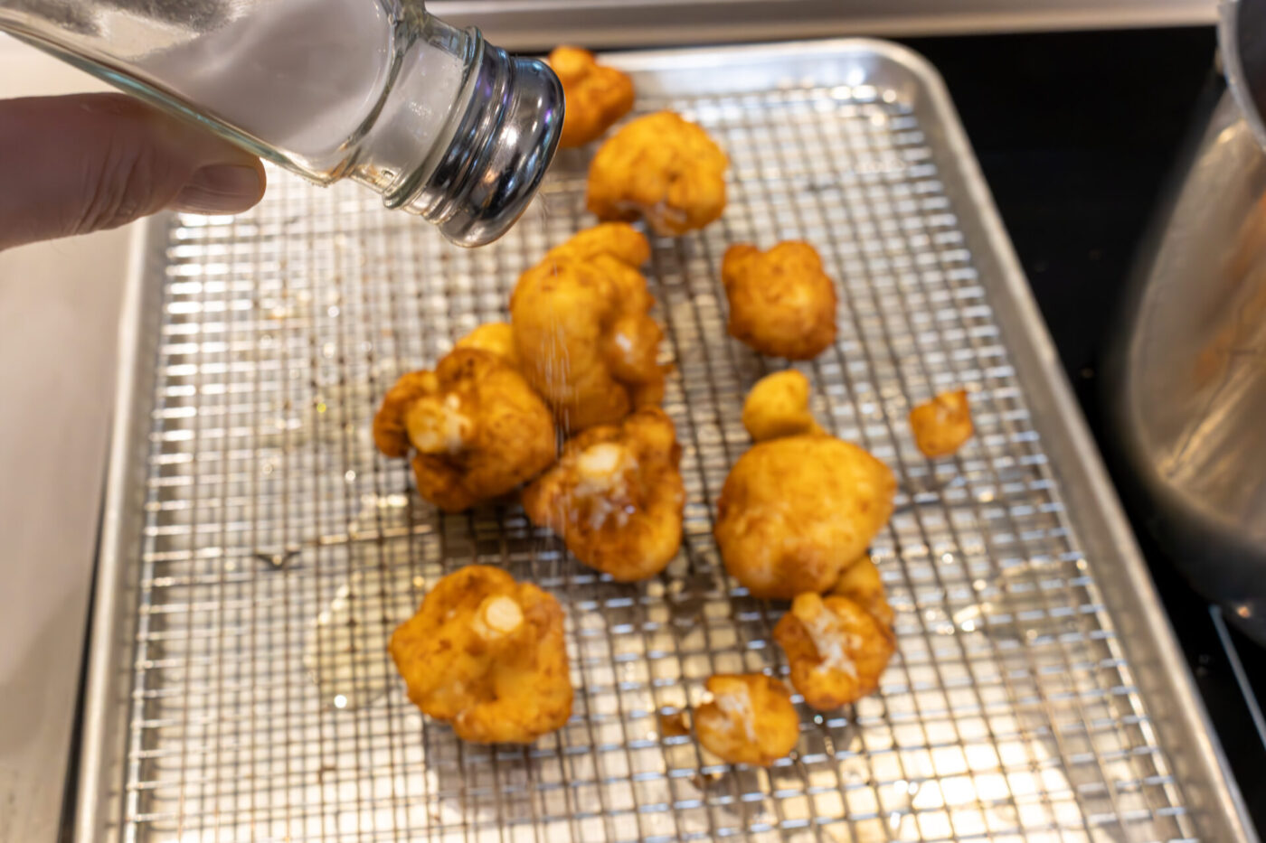 Salting of Fried Cauliflower Smažený Květák right after frying