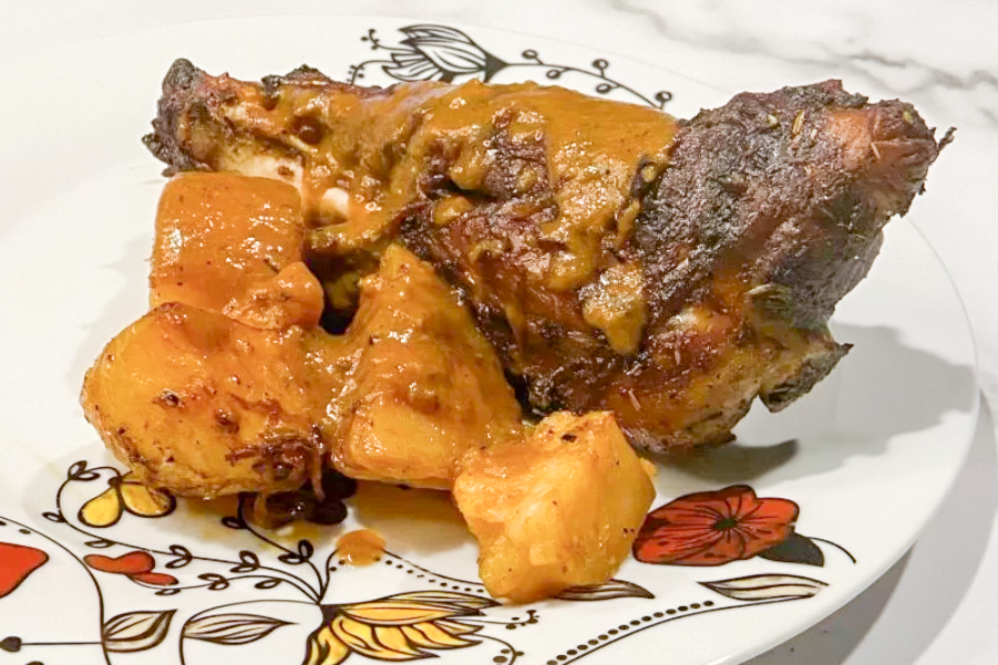 medium distance side shot of Slow-Roasted Lamb Shanks with Crispy Potatoes and Onion Gravy