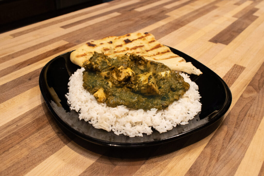 distance side top shot of Spinach Palak Paneer on the rice on the plate