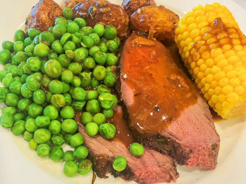 Roast Beef with Garlic Butter in detail side shot with sides