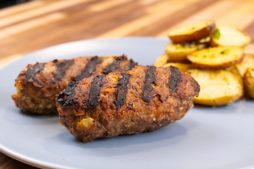 Cevapcici Sausage with Cheese on the blue plate, close up side shot