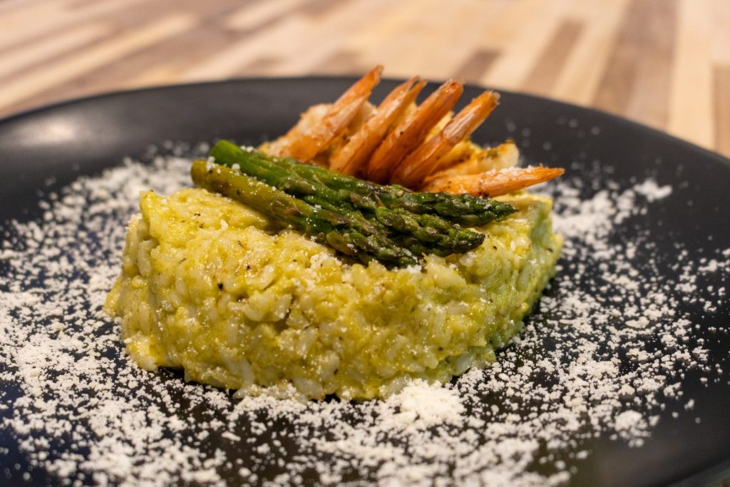 Top side close up shot of Aspragarus Risotto with Shrimp on the black plate