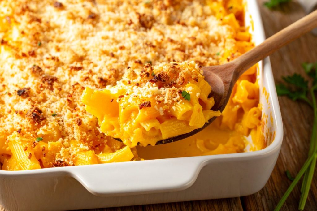 detail front shot of freshly made1. Creamy Butternut Squash Mac and Cheese just being scopped with wooden spoon