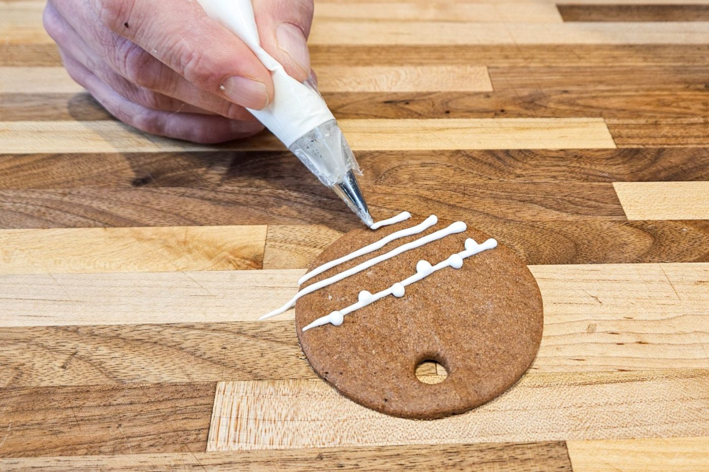 Demonstration of how to decorate gingerbread cookies as round ornaments.