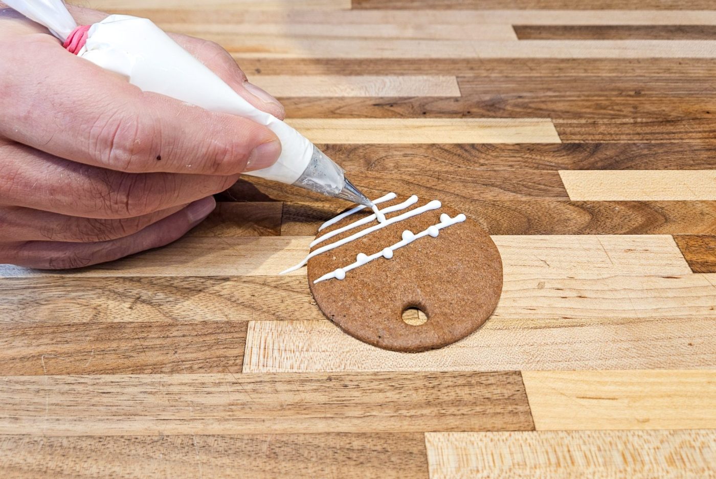 Demonstration of how to decorate gingerbread cookies as round ornaments.