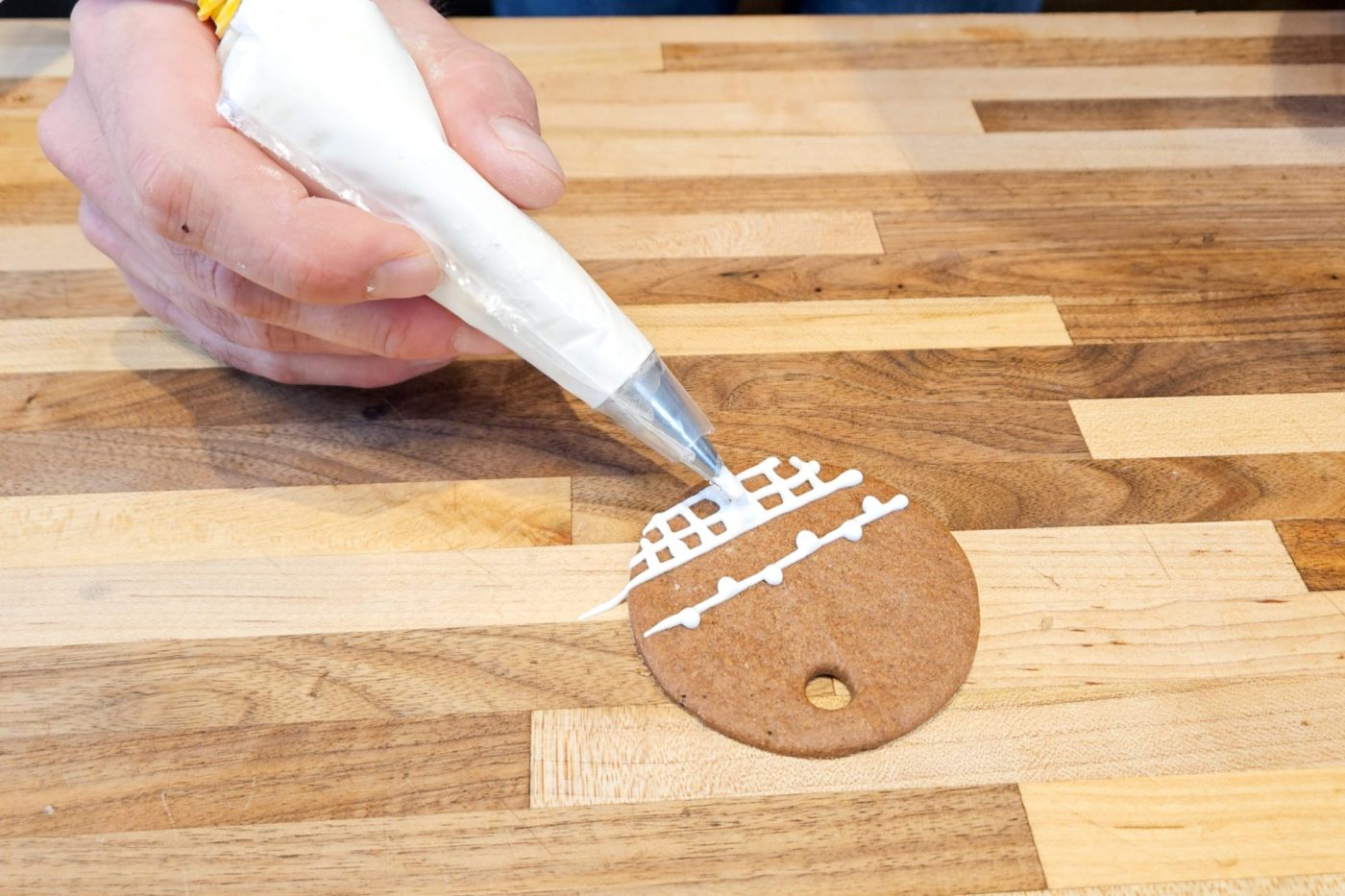 Demonstration of how to decorate gingerbread cookies as round ornaments.