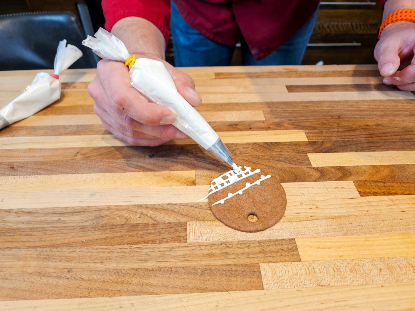 Demonstration of how to decorate gingerbread cookies as round ornaments.