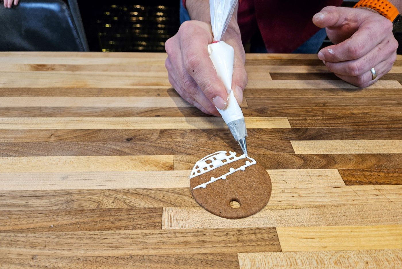 Demonstration of how to decorate gingerbread cookies as round ornaments.