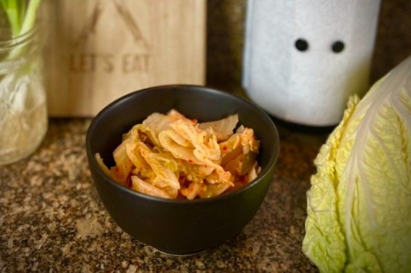 Easy Kimchi in the mixing bowl serrounded with napa cabbage and other ingredients