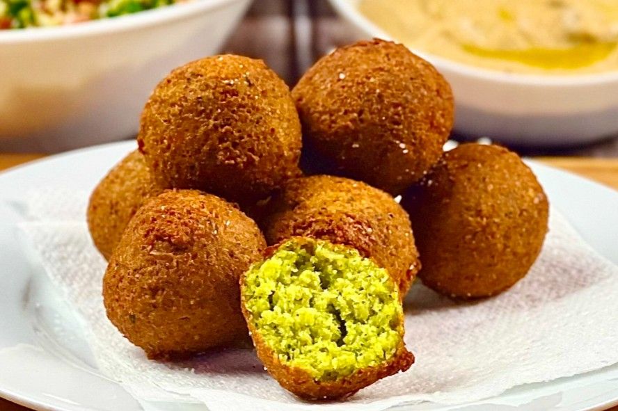 Falafel recipe on the white plate, detail side shot with other food in the background