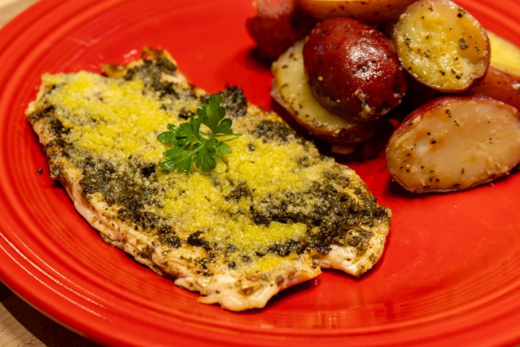 Baby Red Potatoes with Butter on the red plate with pesto chicken breast, top close up shot