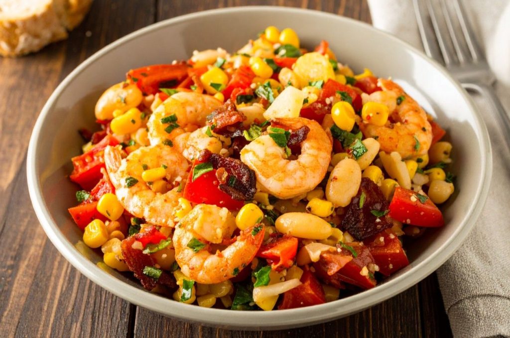 Shrimp Succotash in the white bowl on the rustic table, close up side shot