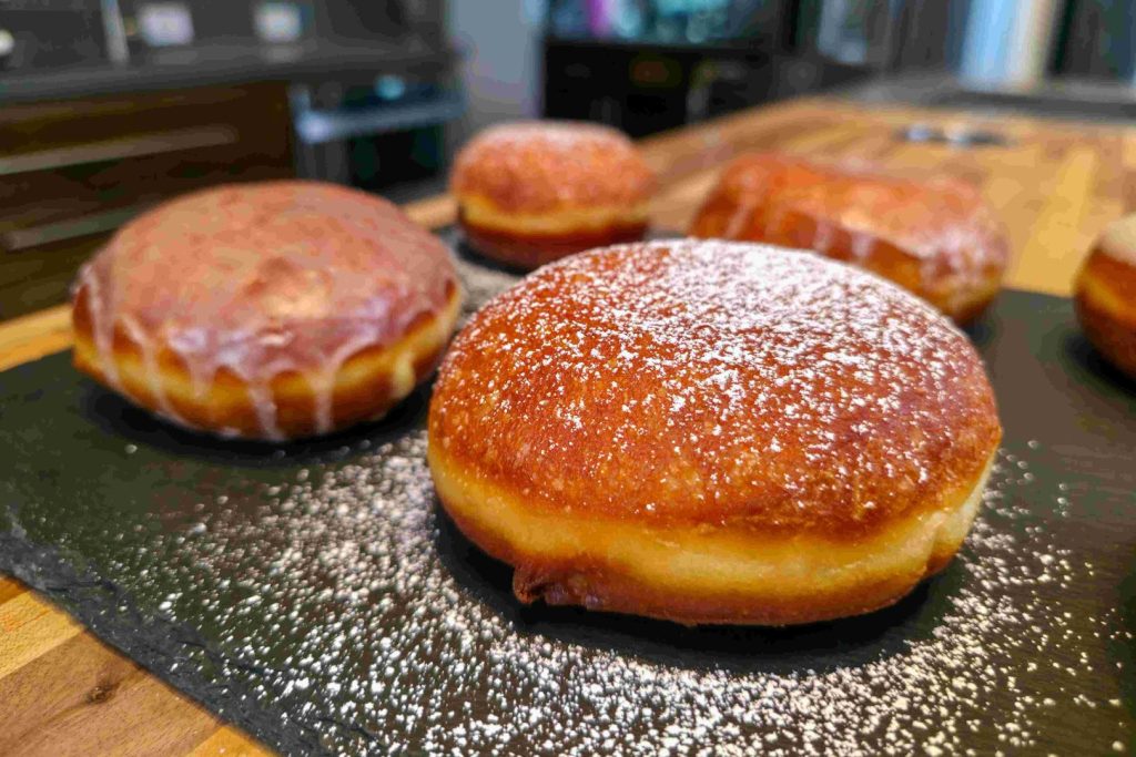 Czech Filled Donut kobliha on the black tray in the detail side shot with kitchen in the background