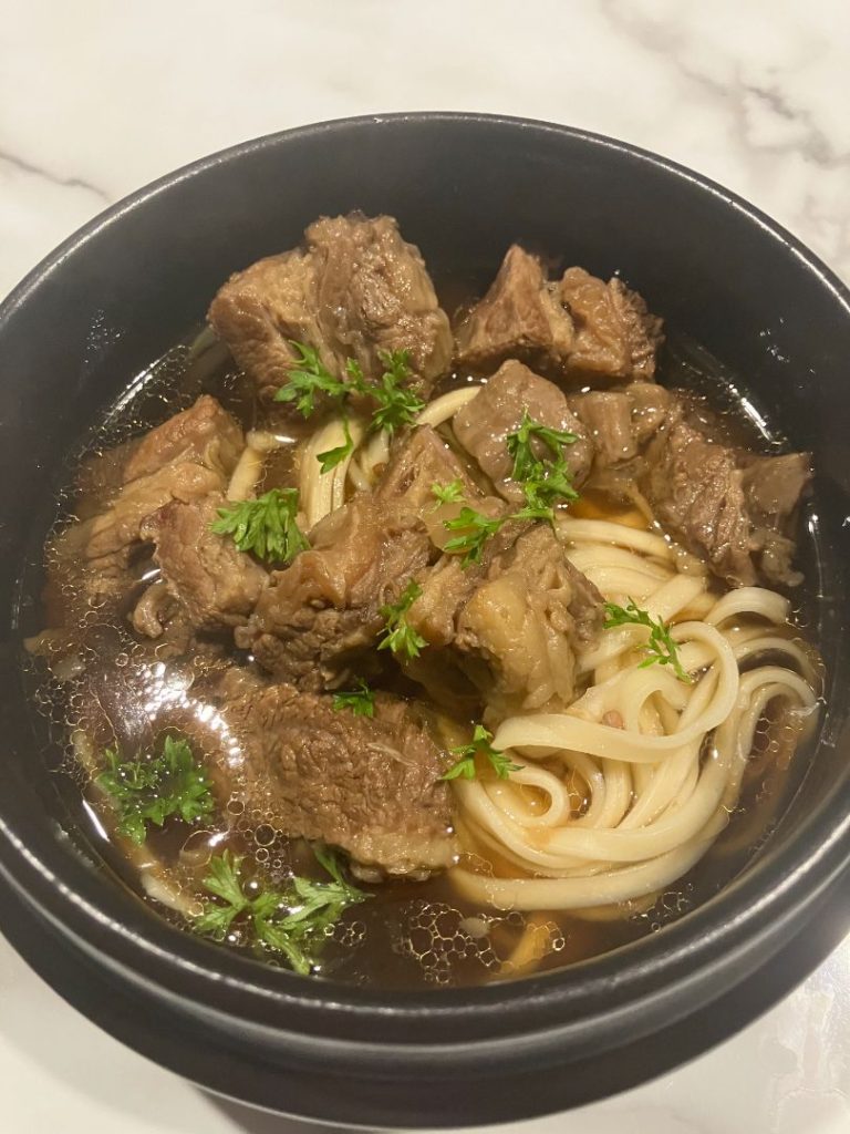 Beef Short Rib Noodle Soup (Bone-In) in the bowl with noodles, top detail shot.